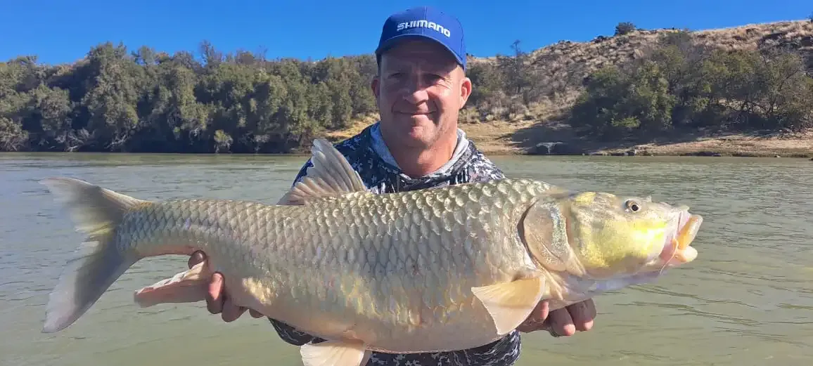An angler holding a largemouth yellowfish in the Orange River