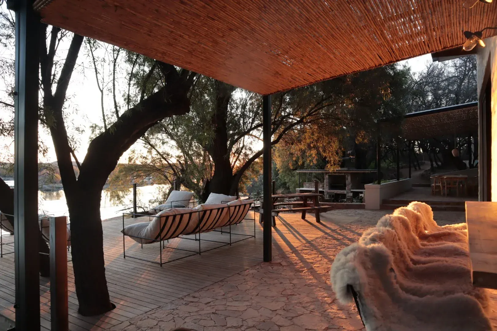 The River House deck beneath mature riverside trees