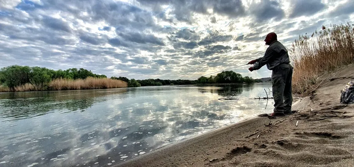 An angler casting from the bank of the Orange River