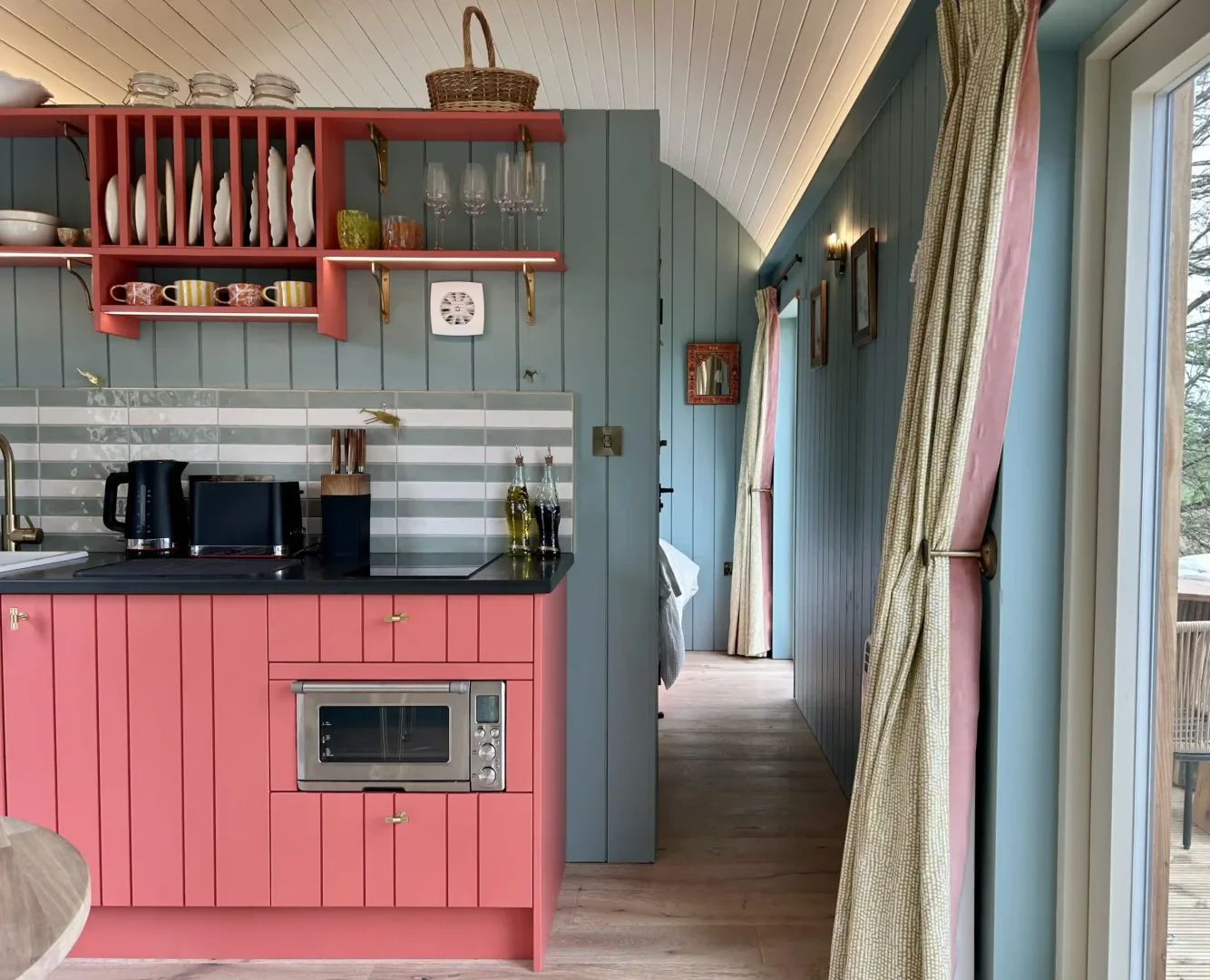 Milkwood's compact kitchen with pink cabinetry