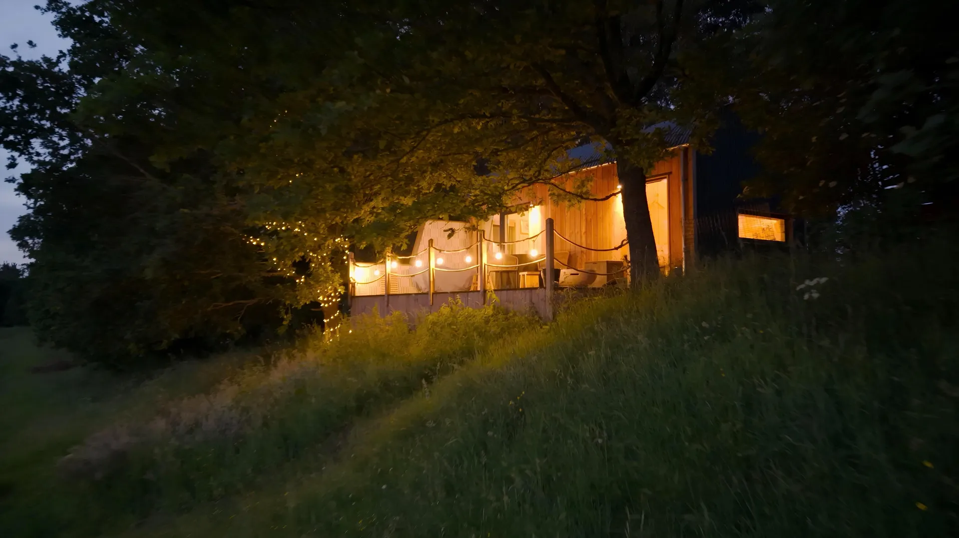 Fairlight cabin at dusk with string lights in the trees
