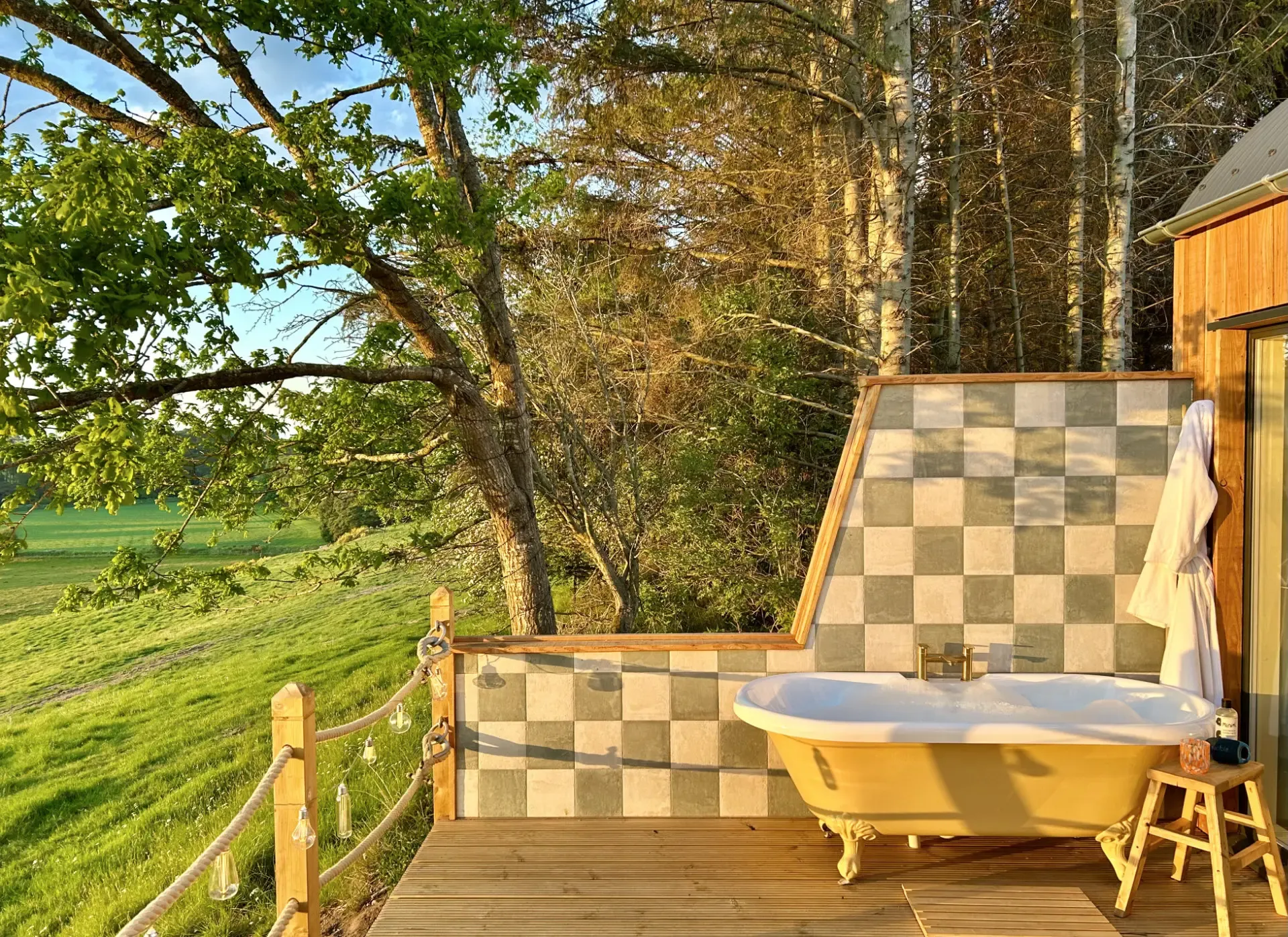 Milkwood's outdoor bath overlooking fields and the River Isla