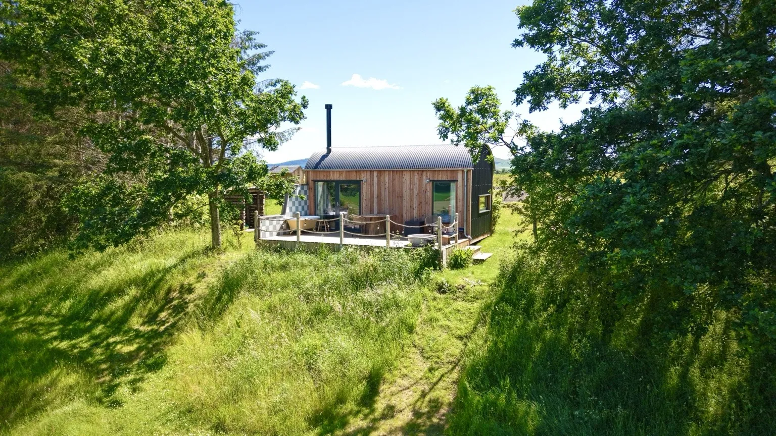 Milkwood cabin and deck framed by trees