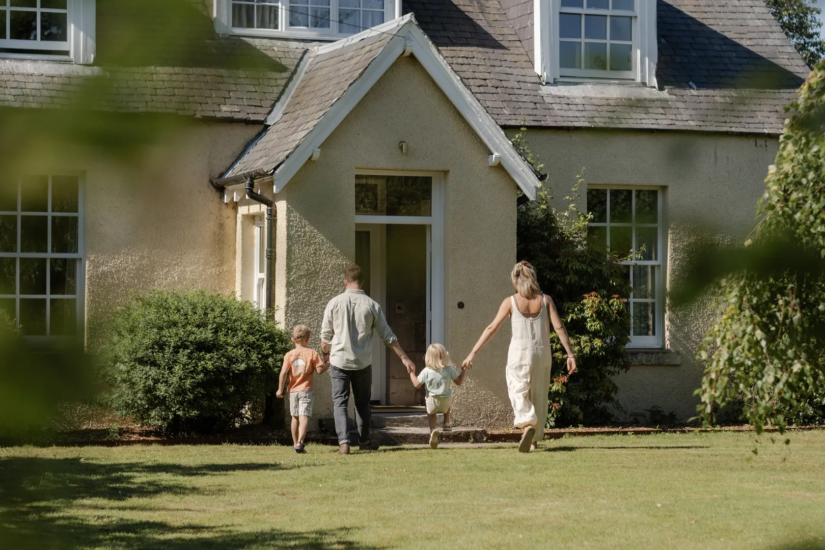A family walking across the lawn towards Links Farmhouse