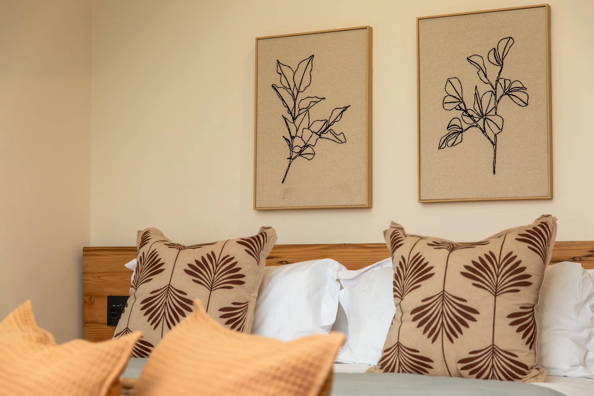 Pillows and botanical prints in the Sea Facing Apartment bedroom