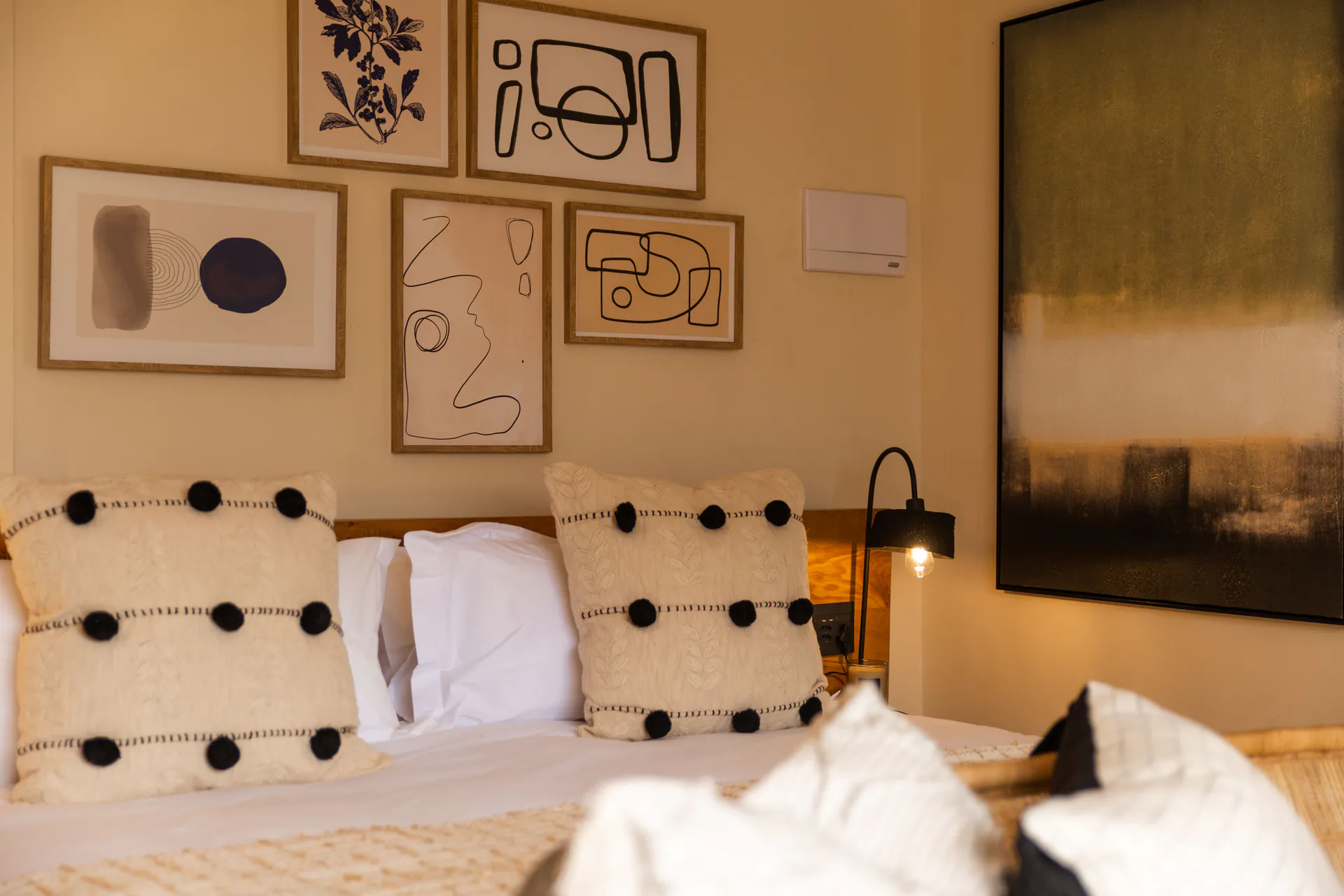 Family Room pillows and framed art above the bed