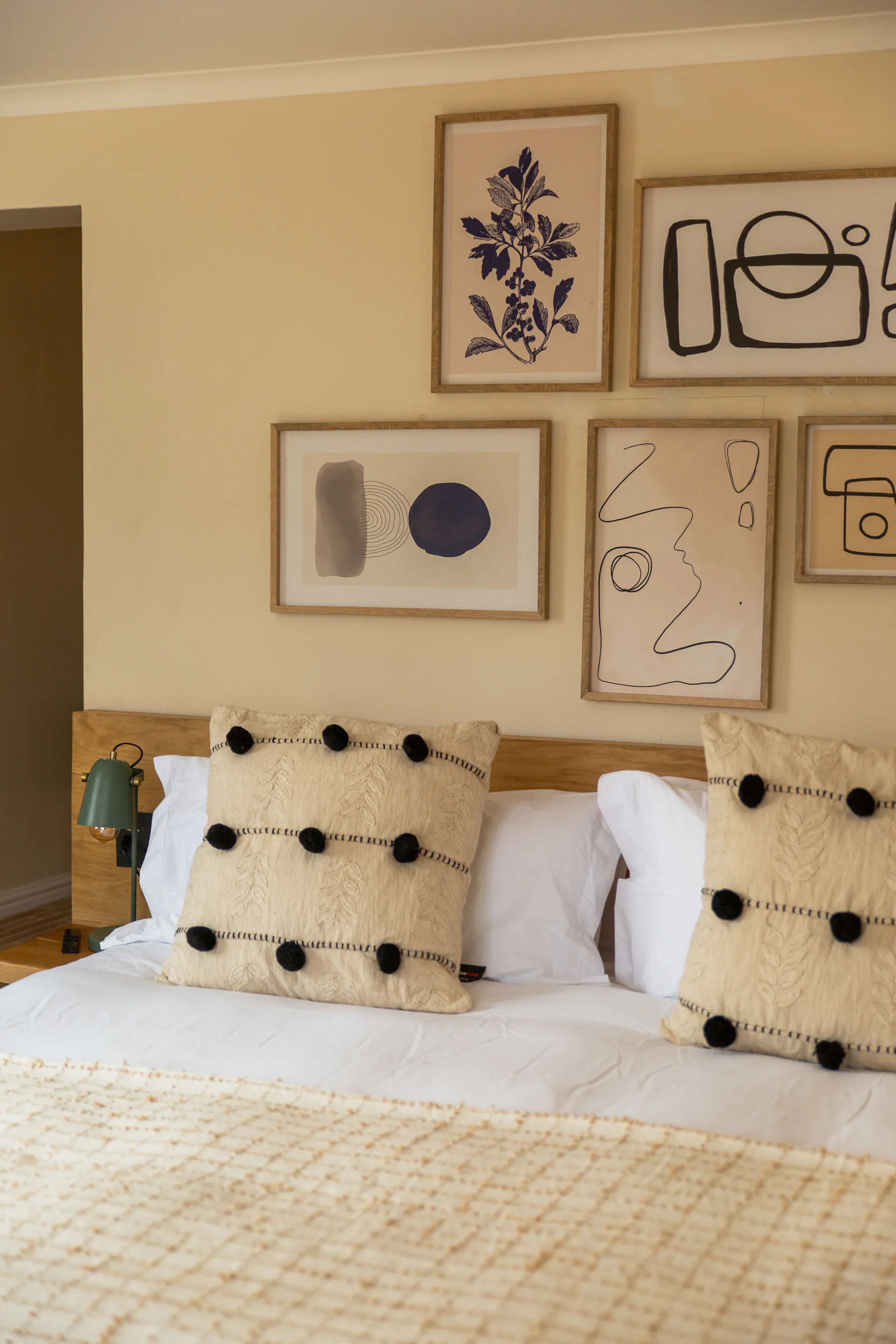 Gallery wall and pom-pom cushions on the Standard Garden Room bed