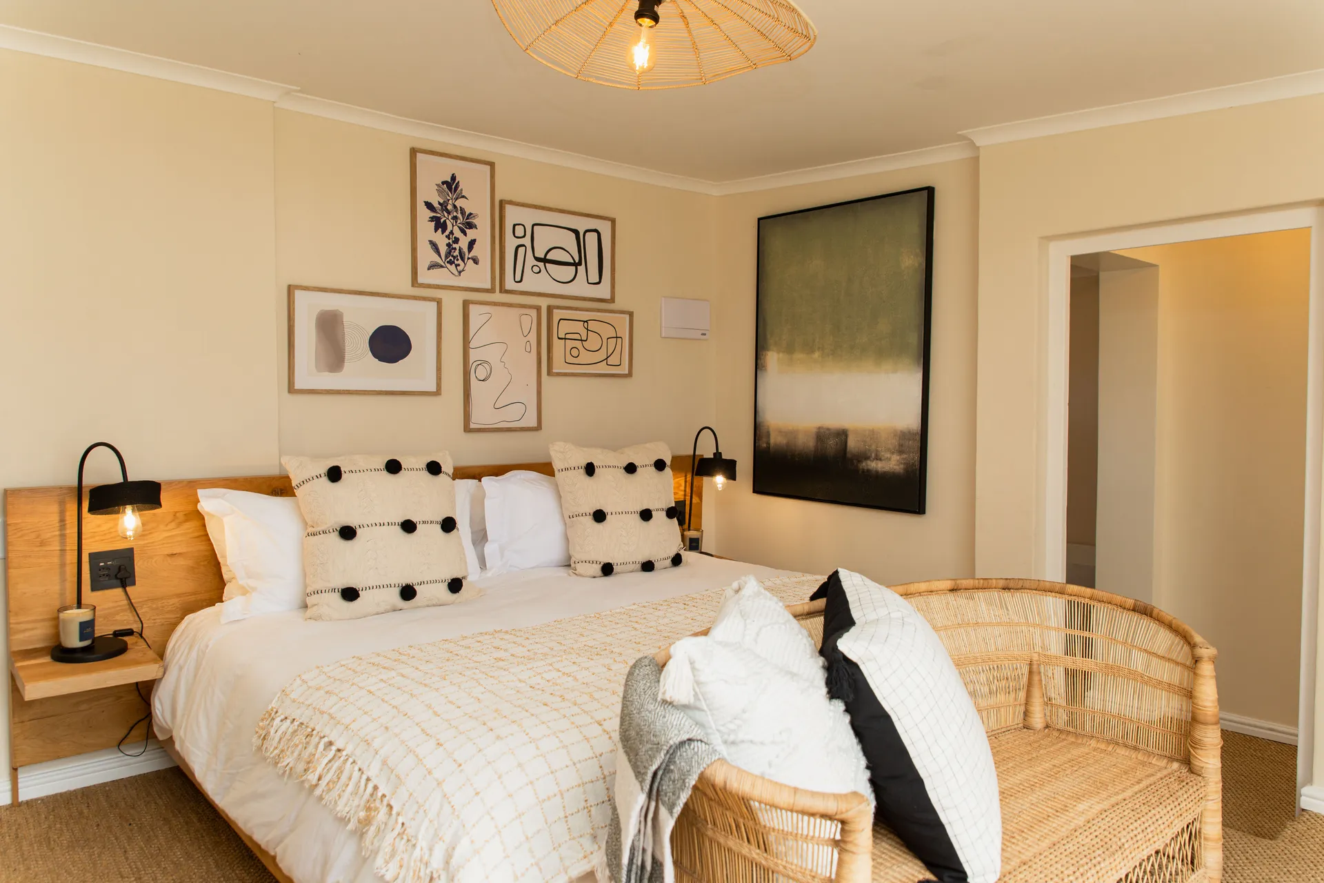 Family Room bedroom with gallery wall and rattan bench