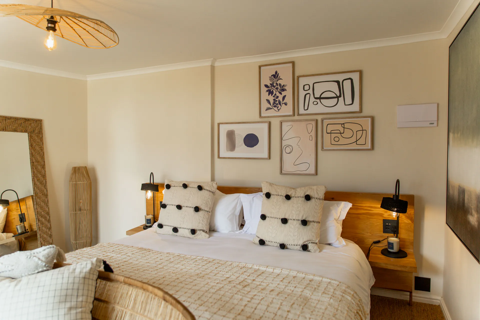 Family Room bed with gallery wall and black lamps