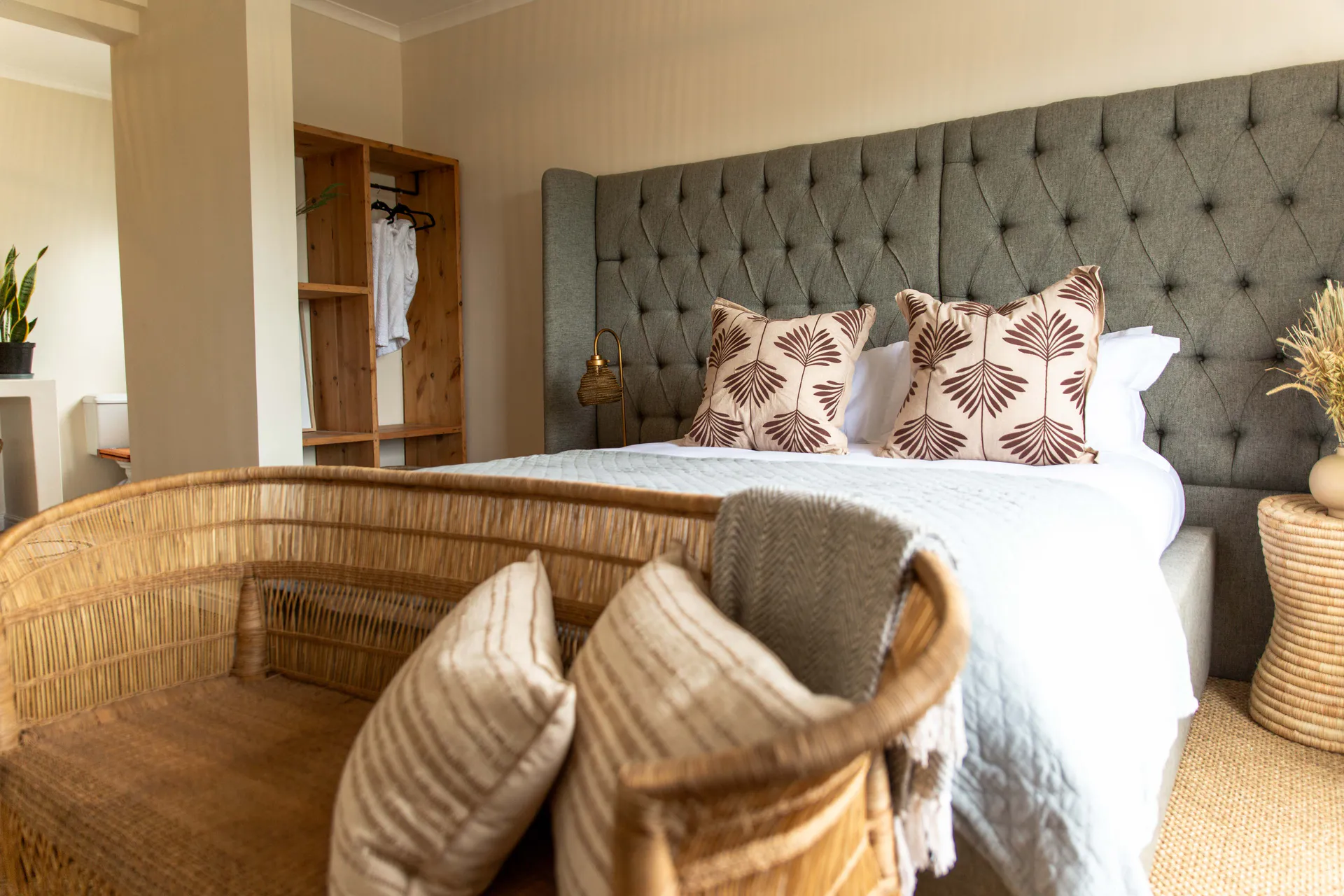 Ground Floor Apartment bedroom with tufted headboard and rattan seating