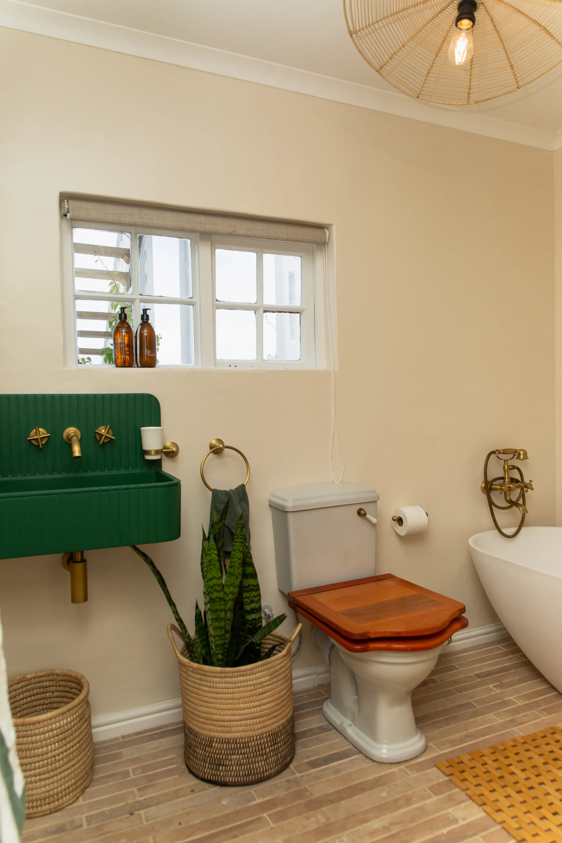 Family Room bathroom with basin, bath and rattan pendant