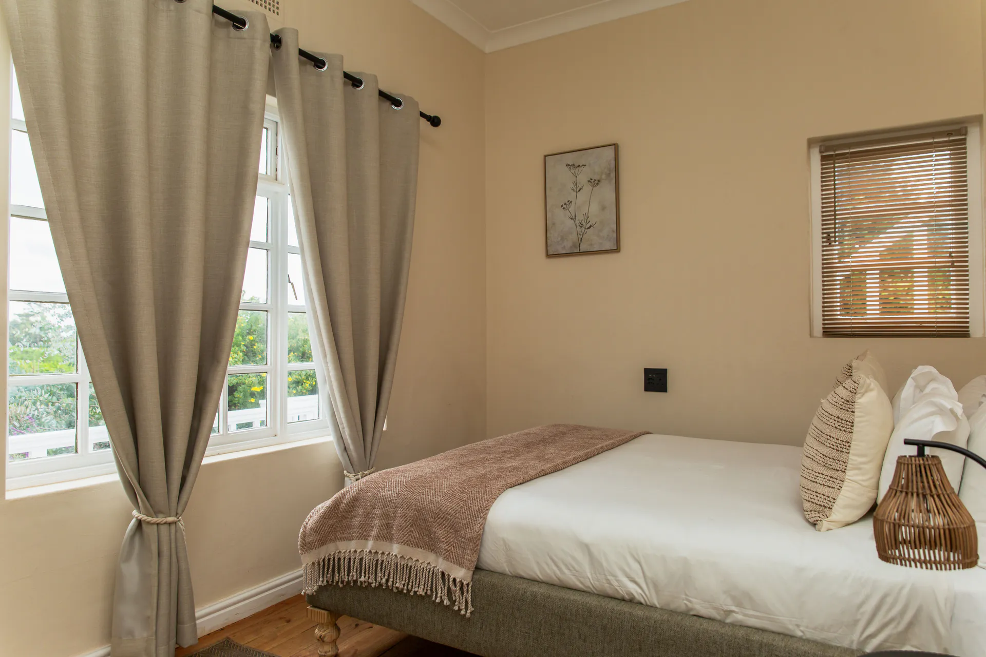 Ground Floor Apartment bed beside a garden window