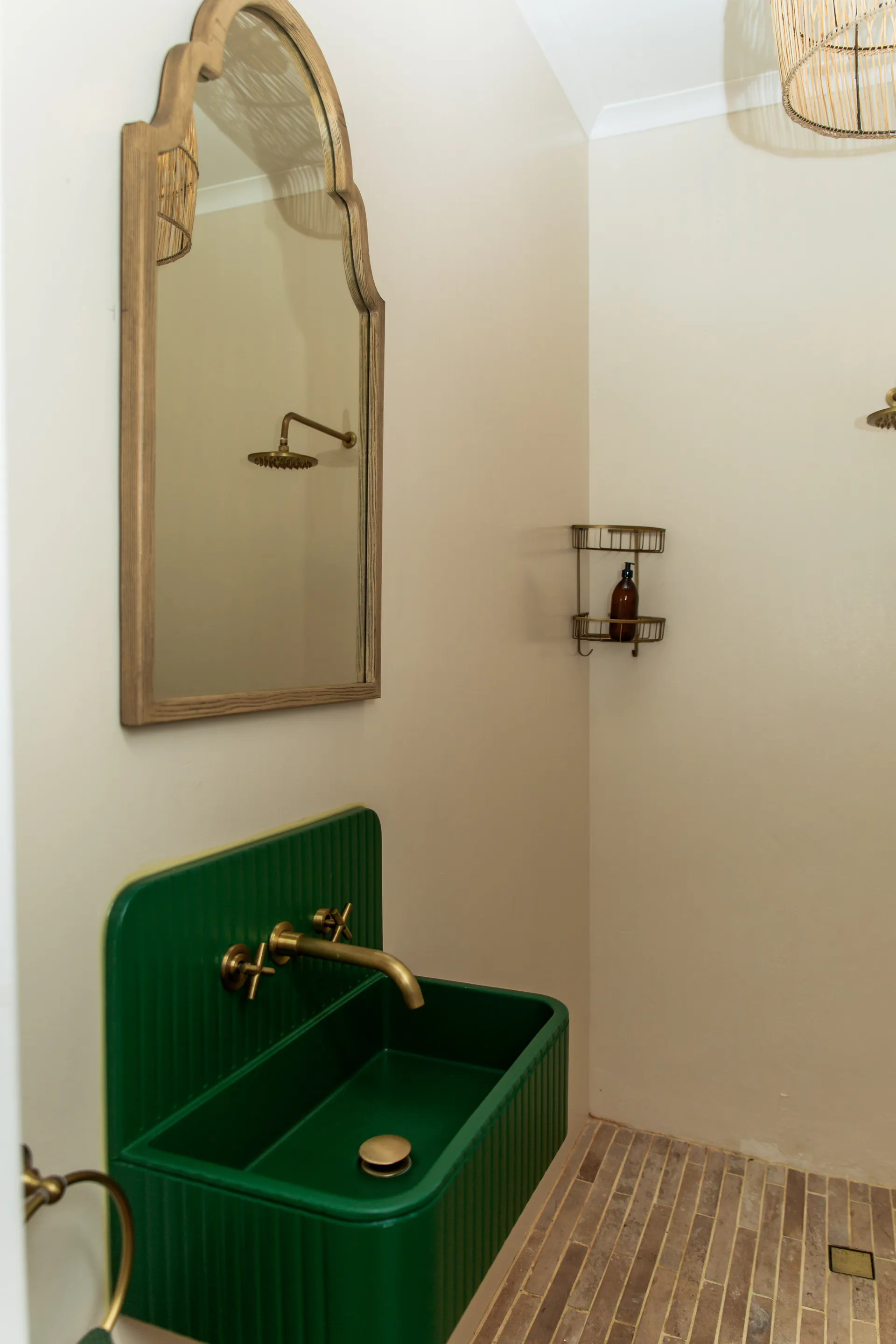 Green fluted basin and brass taps in a Ground Floor Apartment bathroom