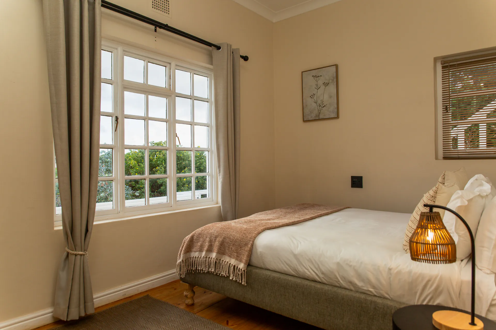 Ground Floor Apartment bedroom with rattan lamp and garden window