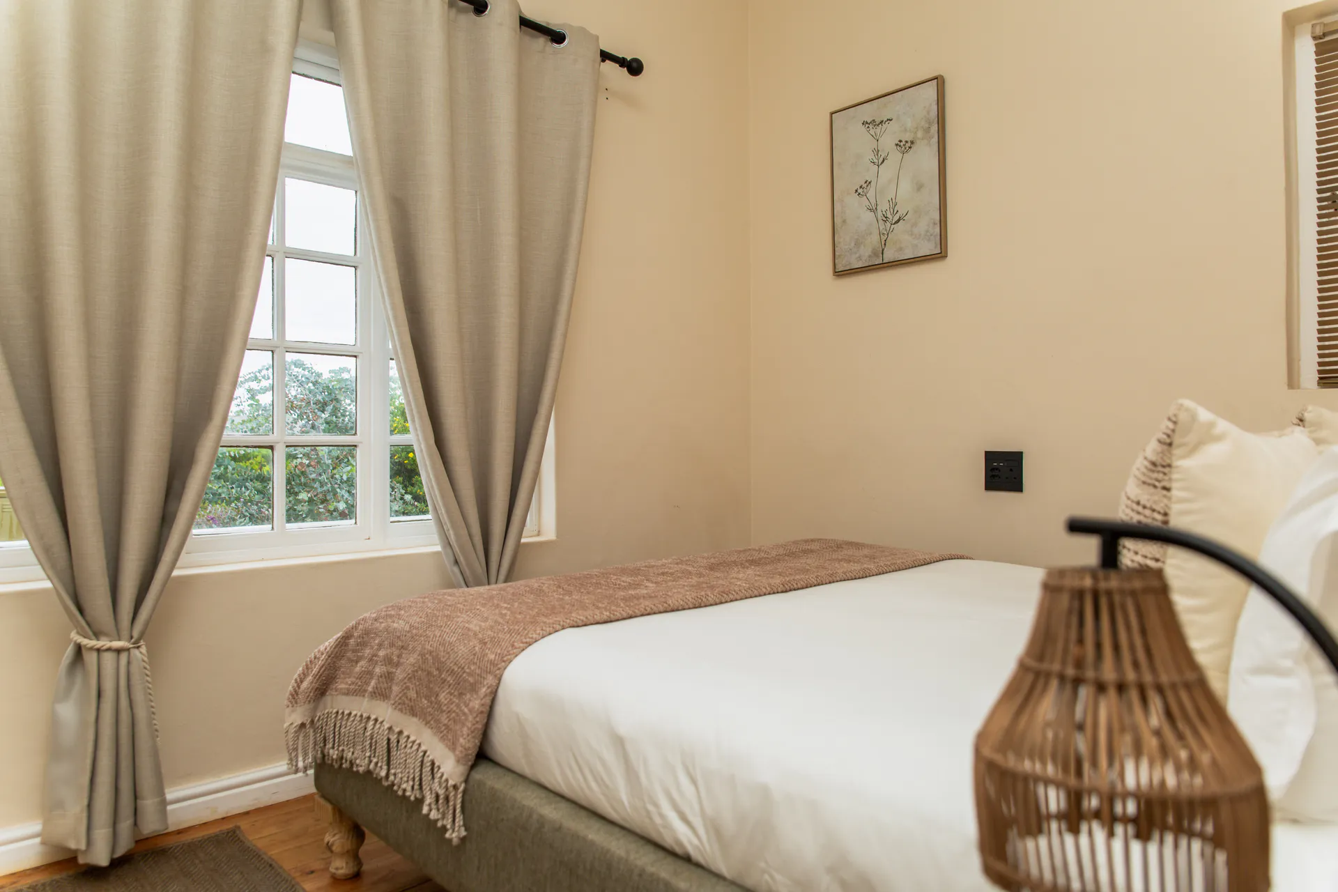 Ground Floor Apartment bedroom with garden window and rattan lamp