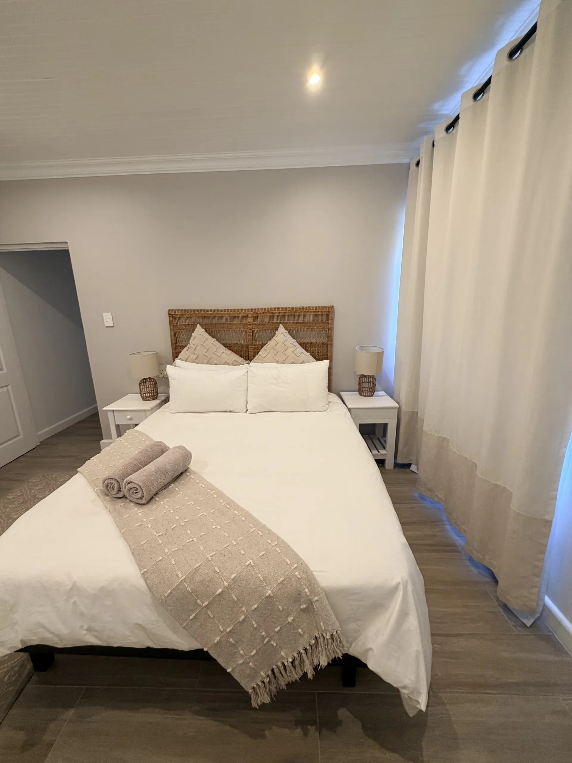 Bedroom with a woven rattan headboard and cream bedding