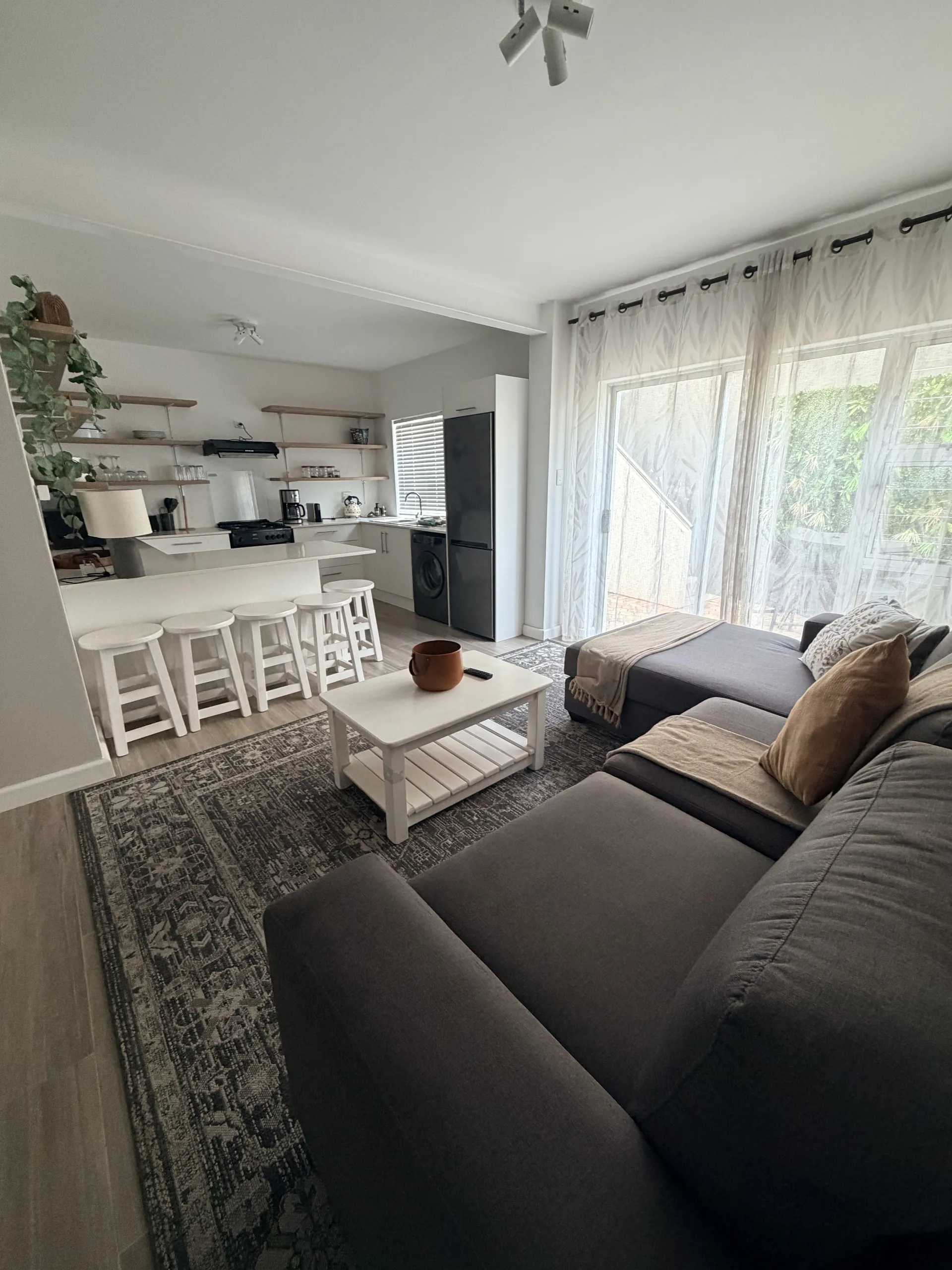 Open-plan living room and kitchen with a grey sofa and breakfast bar