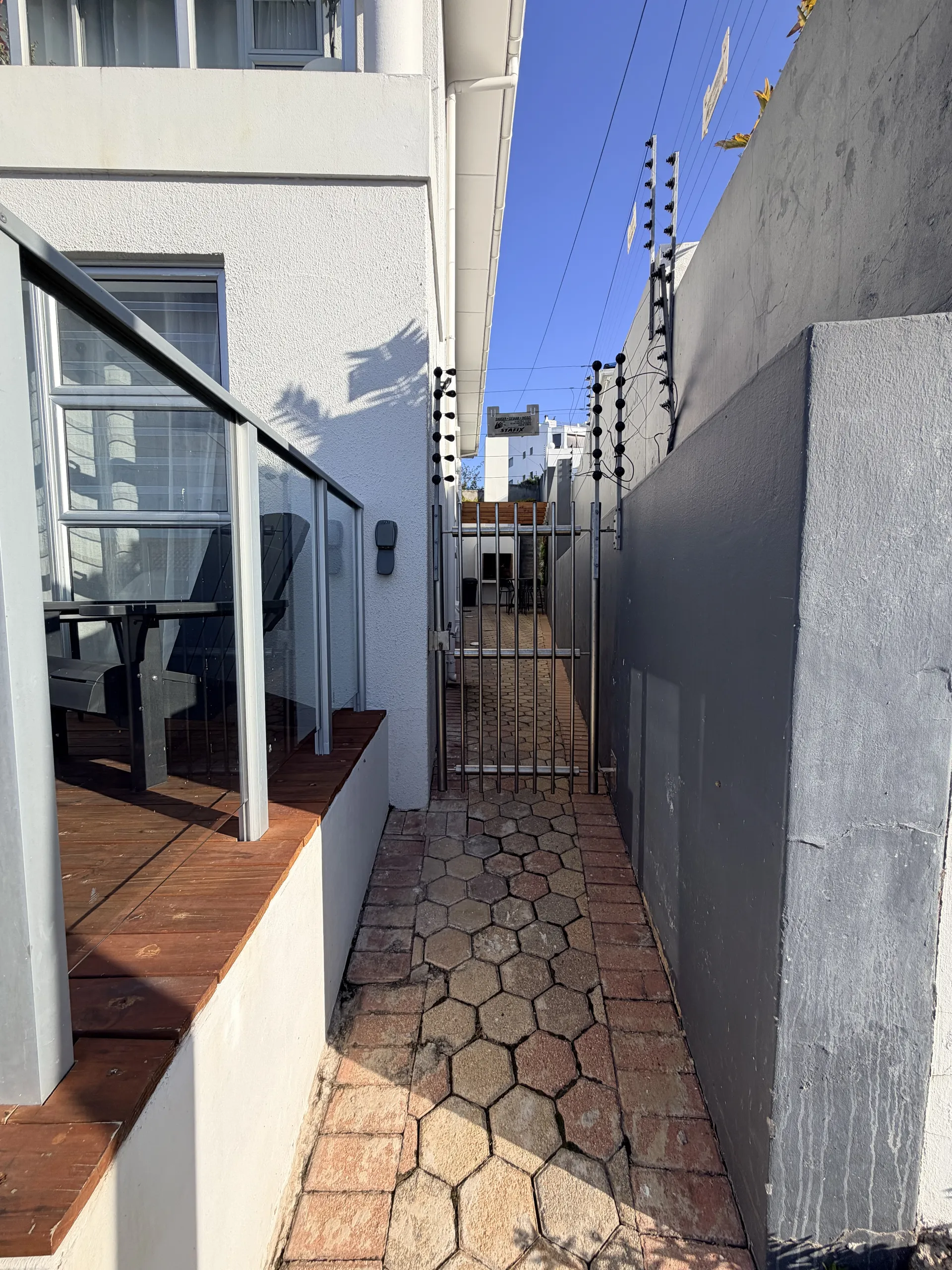 Side passage with a wooden deck and security gate