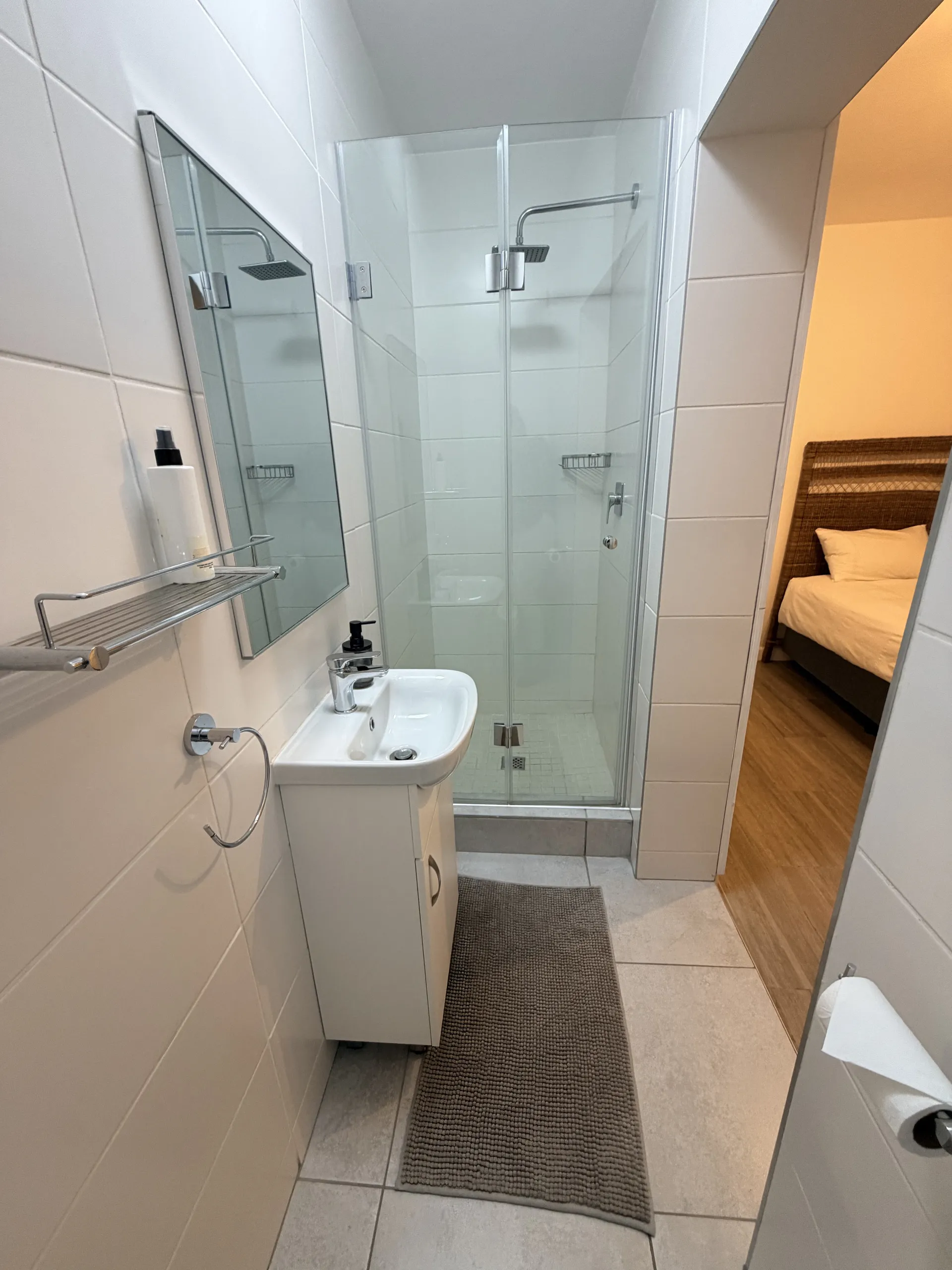 Ensuite with a glass shower beside the bedroom