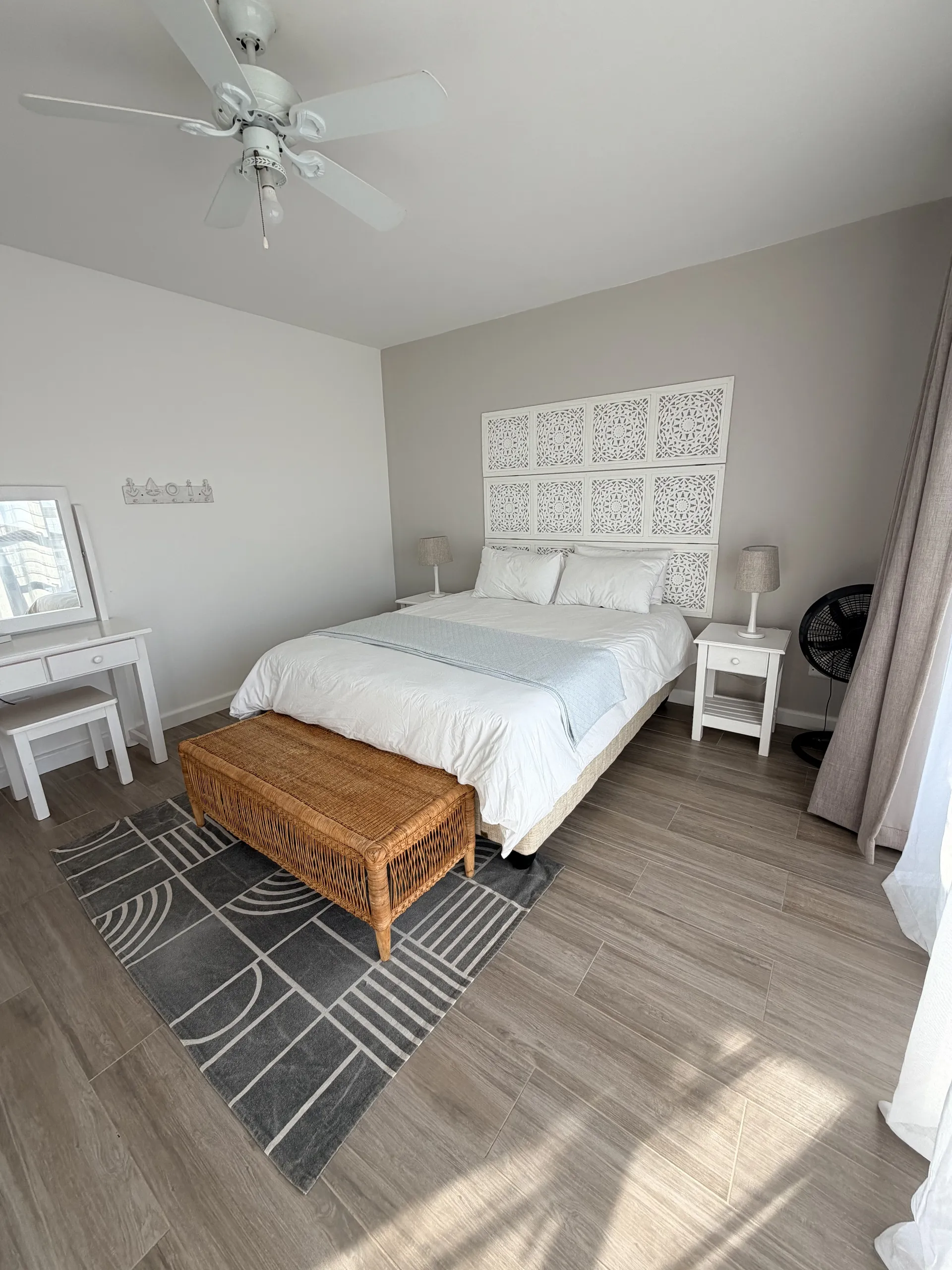 Queen bedroom with a carved headboard and rattan bench