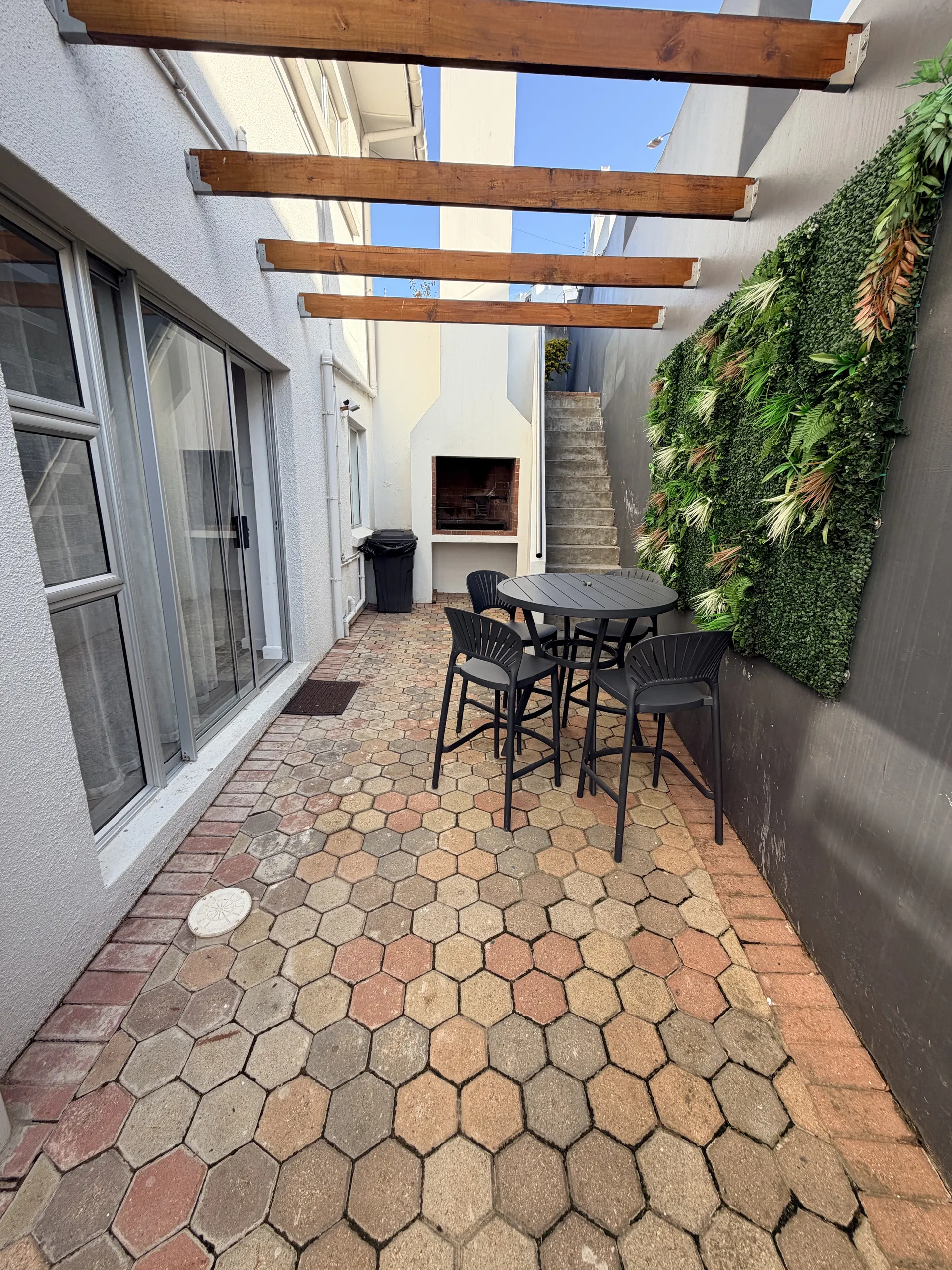 Private courtyard with outdoor dining, a green wall and braai