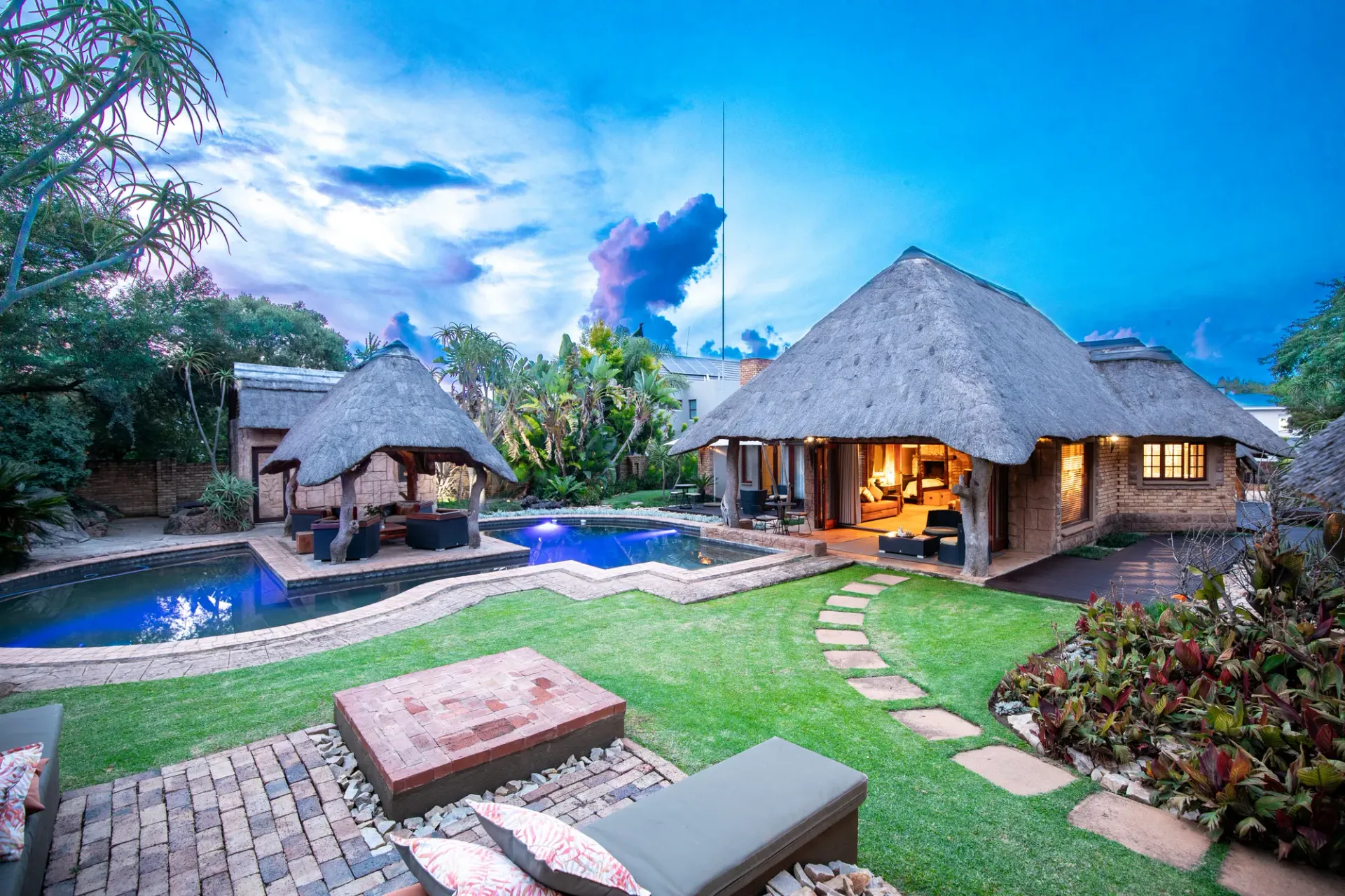 Thatched Wings & Water guest villa and swimming pool at dusk
