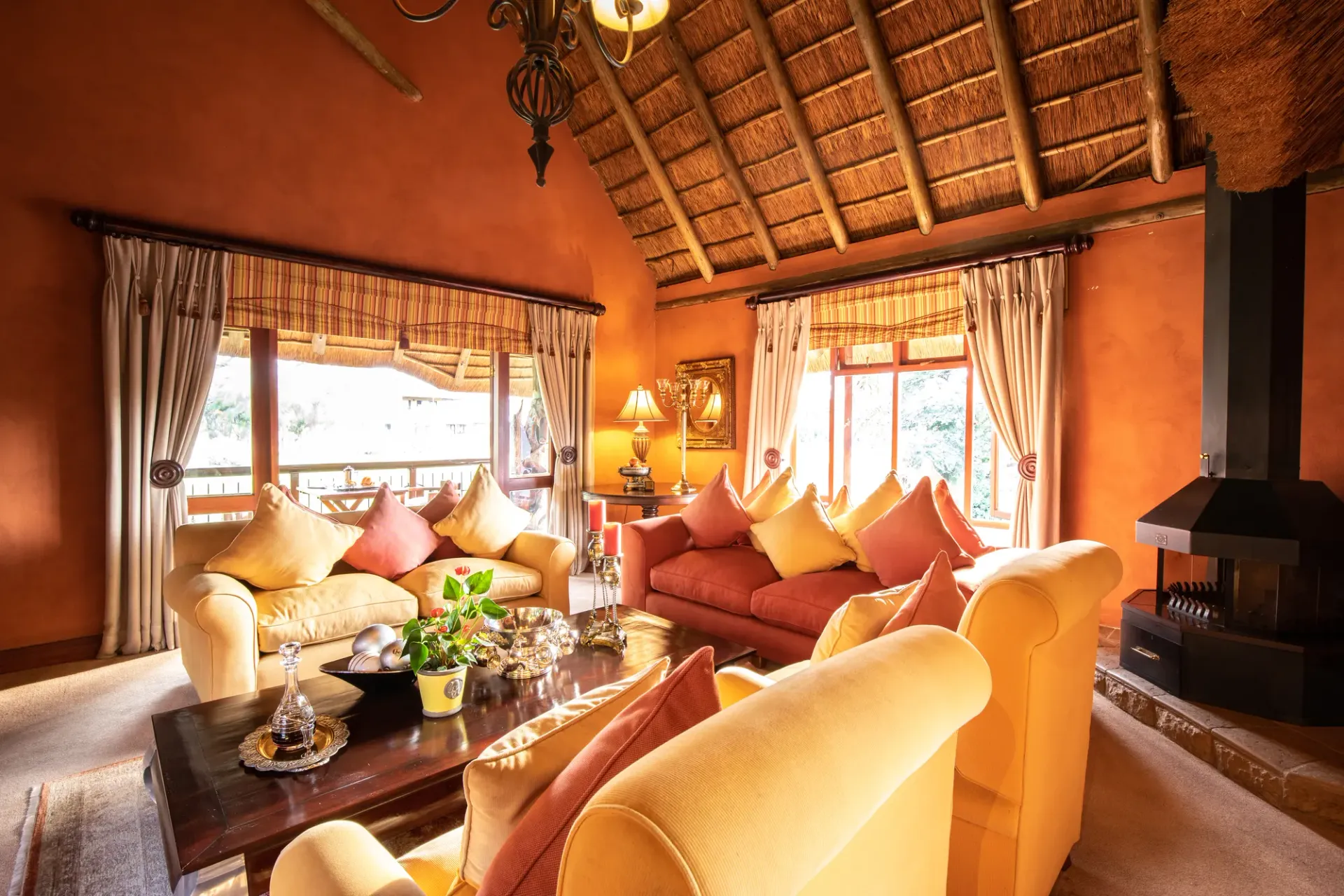 Communal lounge with a thatched ceiling, sofas, and fireplace